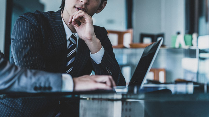 事業戦略や意思決定について思案するビジネスマン