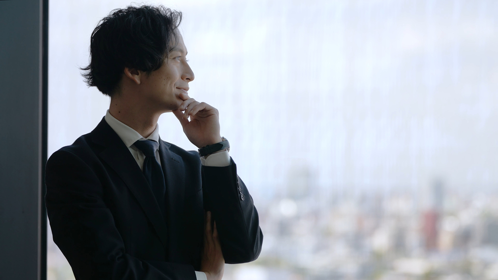 会社の買収について思索するスーツ姿の男性