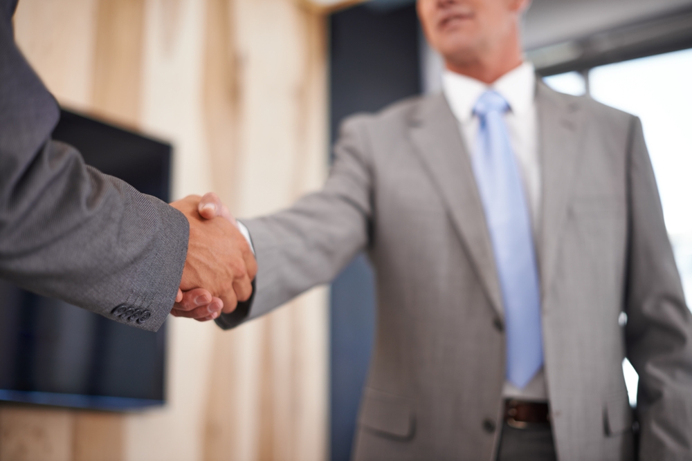 事業承継の合意を握手で確認する前オーナーと後継者候補