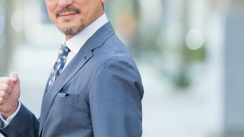 スーツ姿でガッツポーズをする経営者